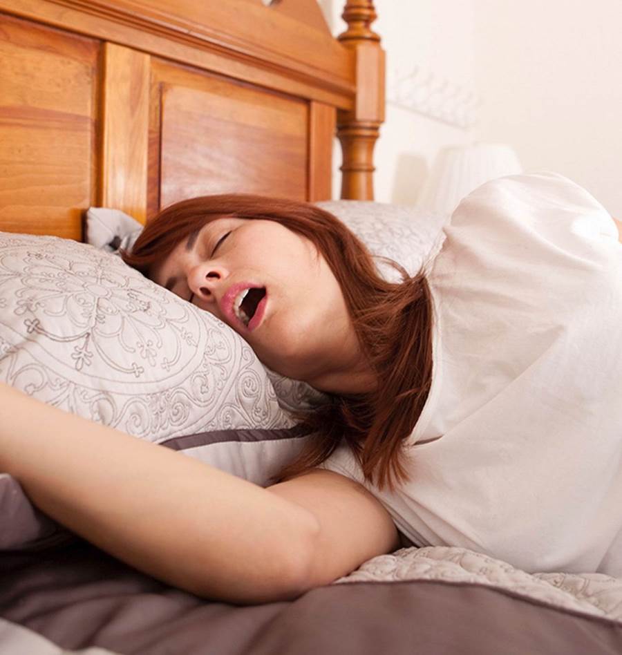 Женщина спит с открытым ртом и храпит